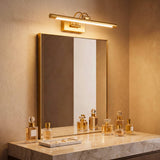 Aplique de pared dorado aportando sofisticación y luz funcional en un mueble de baño de mármol de lujo.