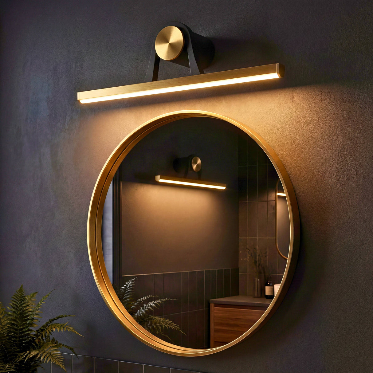 Ambiente de baño contemporáneo con luminaria lineal sobre espejo redondo que aporta luz perimetral.