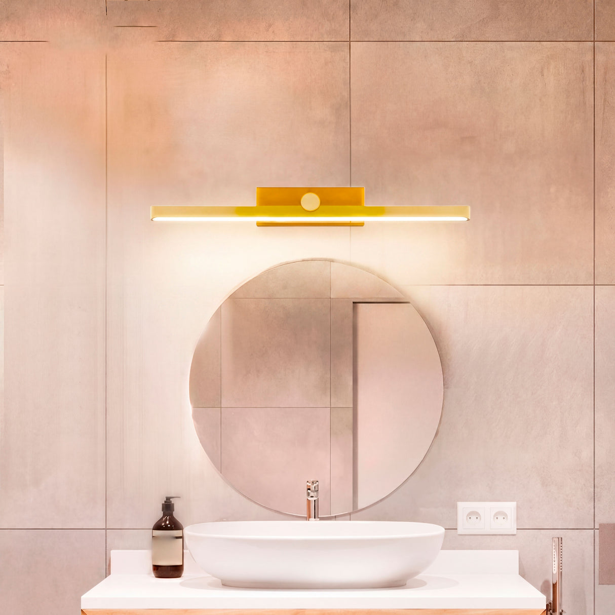 Aplique de pared dorado sobre lavabo moderno con luz neutra para aseo diario.
