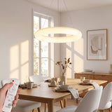 Lámpara de techo circular suspendida sobre mesa de madera en interior de arquitectura moderna.