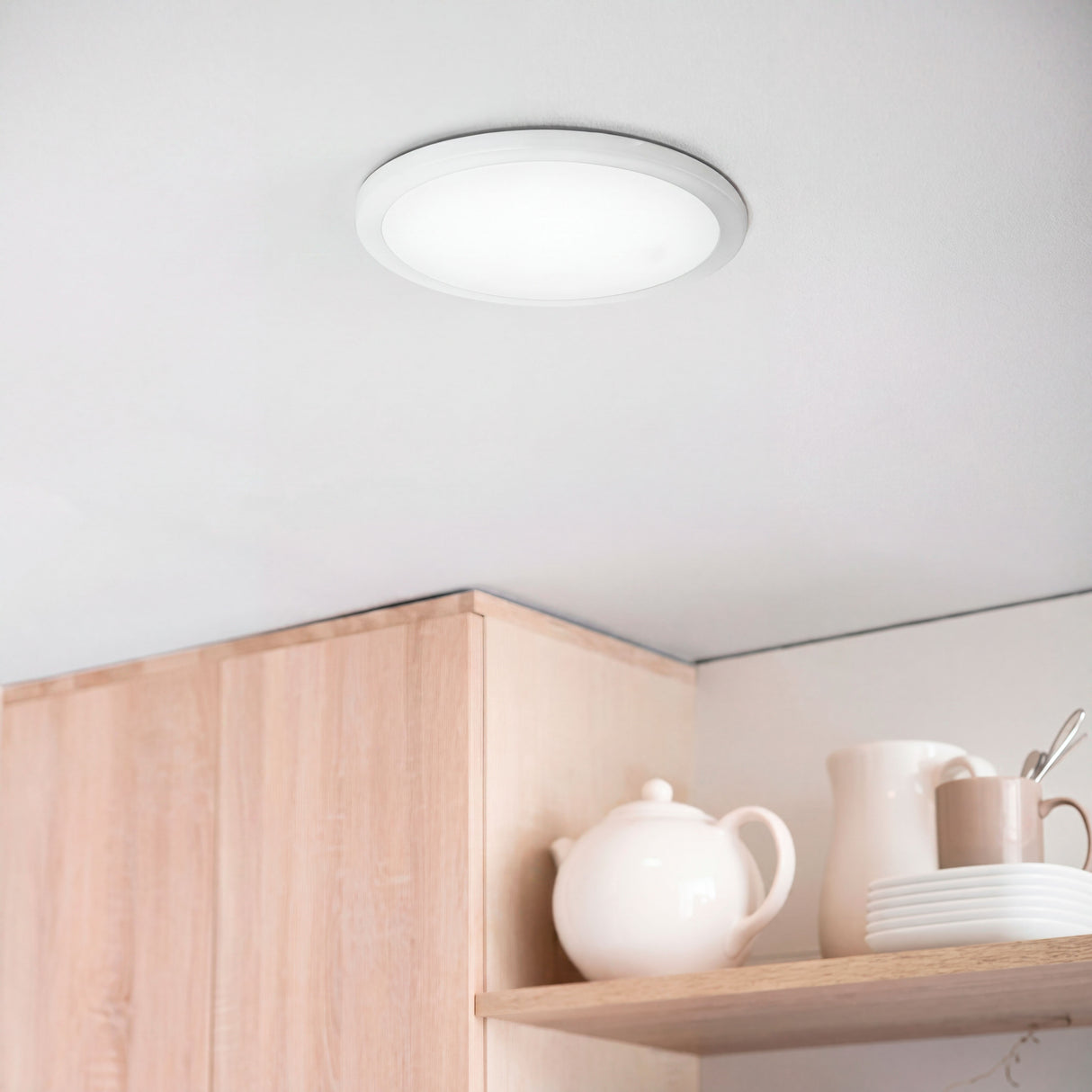 Downlight LED de luz intermedia instalado sobre mobiliario de cocina con acabados en madera.