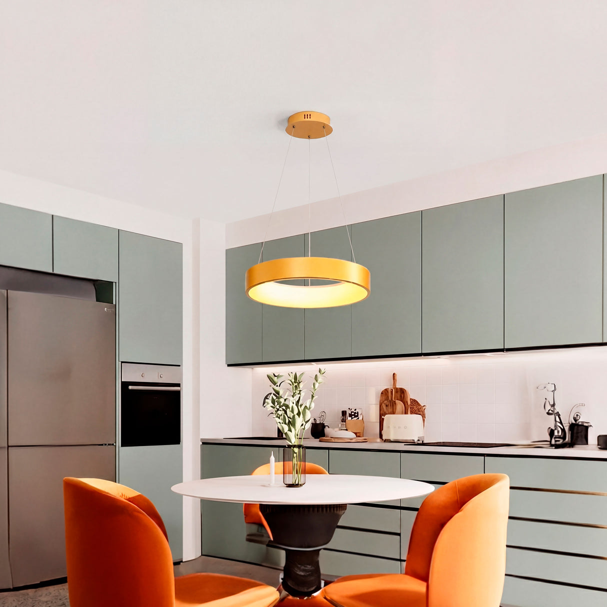 Lámpara colgante circular en oro cepillado sobre mesa de diario en cocina de diseño.
