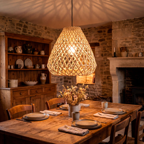Lámpara colgante de fibras naturales sobre mesa de madera maciza en ambiente mediterráneo.