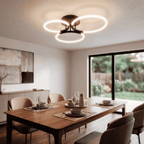 Lámpara de techo sobre mesa de comedor con diseño de líneas puras y luz natural.
