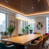 Lámpara colgante blanca sobre mesa de madera en comedor con iluminación de acento.