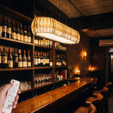 Ambiente de barra de bar con iluminación focalizada ámbar y atmósfera de diseño sofisticado.