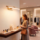 Lámpara Nerina iluminando zona de perfumes en boutique de lujo con luz cálida.