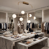 Luminaria de lujo instalada en tienda de ropa boutique sobre mesa de exhibicion.