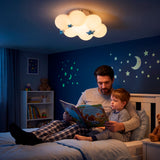 Padre leyendo un cuento a su hijo bajo la luz cálida de la lámpara nube en dormitorio azul.