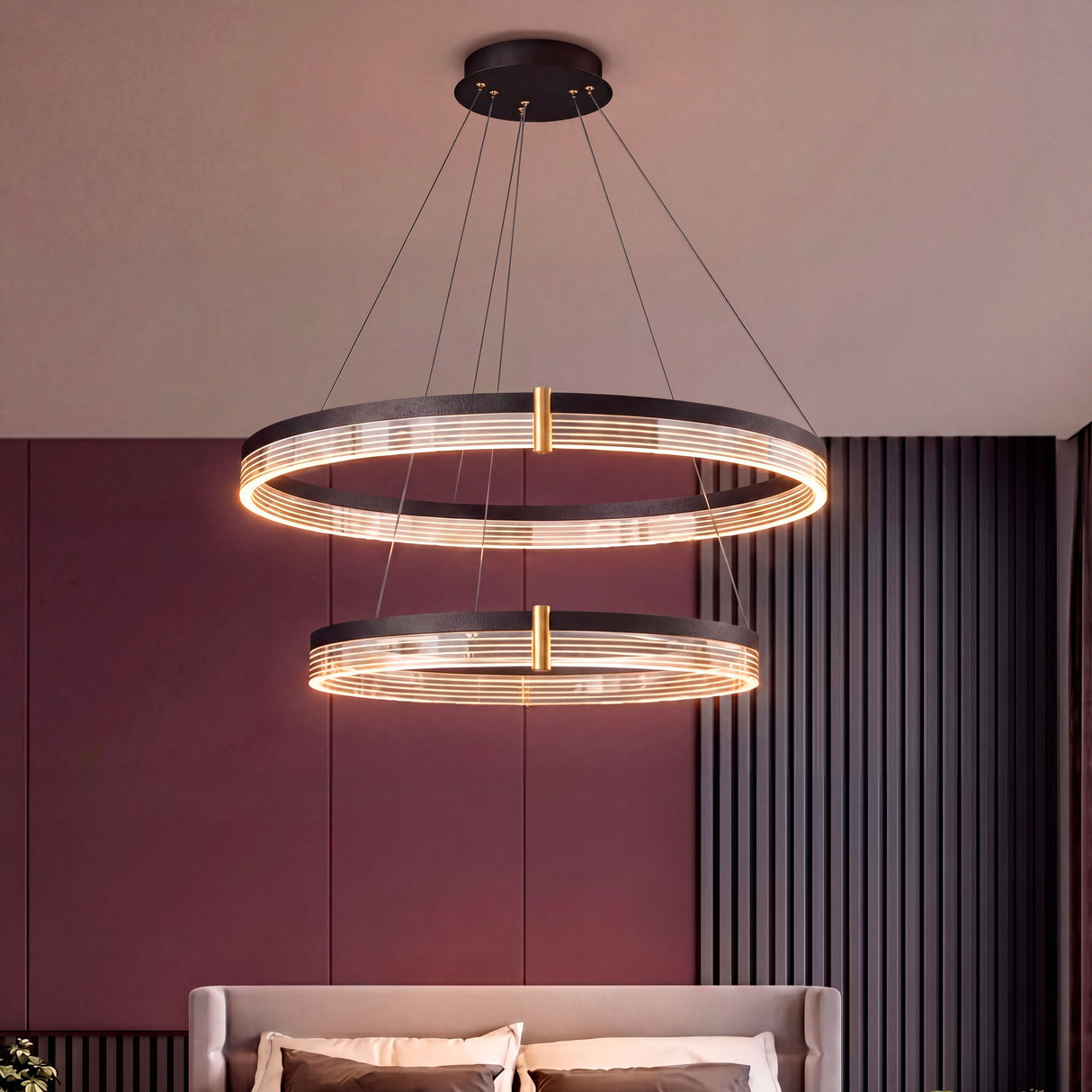 Lámpara Montserrat suspendida sobre cama en habitación con tonos berenjena y neutros.