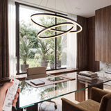 Lámpara de aros negros sobre mesa de cristal en despacho de lujo con estética vanguardista.