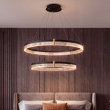 Lámpara colgante de doble aro negro y oro en dormitorio principal con diseño de lujo.