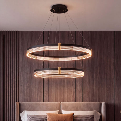 Lámpara colgante de doble aro negro y oro en dormitorio principal con diseño de lujo.