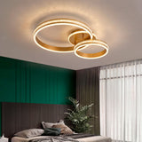 Plafón LED de doble aro dorado con efecto cristal en dormitorio de diseño moderno.
