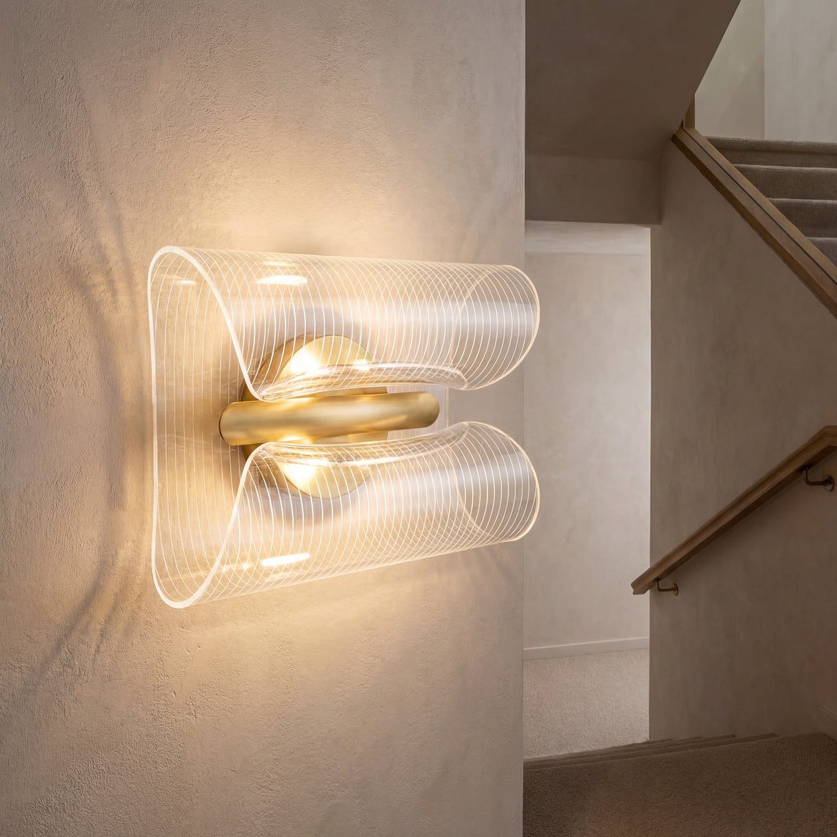 Lámpara de pared instalada horizontalmente en zona de escaleras con luz cálida acogedora.