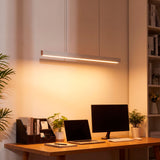 Lámpara de 120cm sobre zona de trabajo con monitores, facilitando el confort visual.