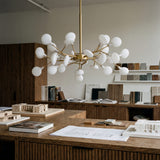 Lampara Sputnik Nativa Gold instalada en un estudio creativo con diseño contemporaneo.