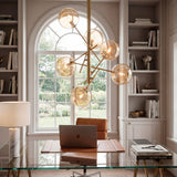 Lámpara de diseño en zona de trabajo con escritorio de cristal y arquitectura clásica.