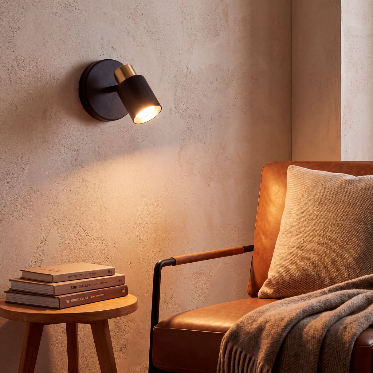 Baño de luz cálida cenital sobre zona de descanso en sala de estar con acabados premium y modernos.