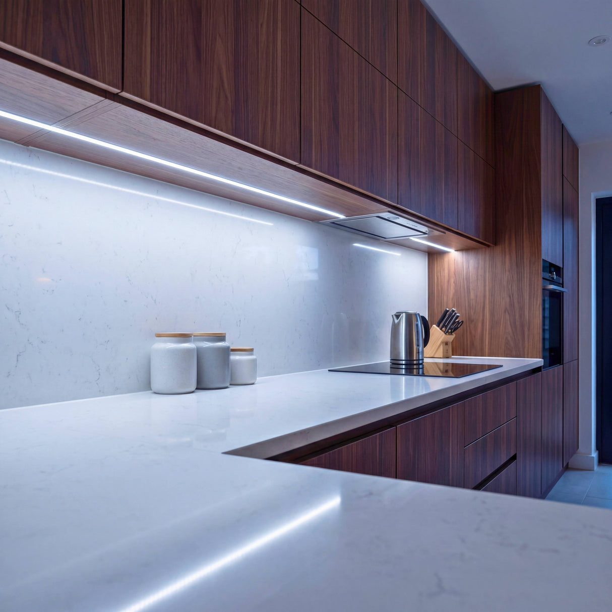 Luz técnica empotrada bajo armarios de cocina moderna para optimizar la visibilidad de trabajo.