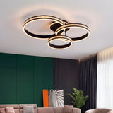 Lámpara circular negra en dormitorio con pared verde y plantas naturales.