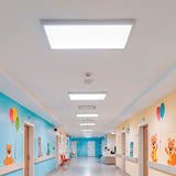 Paneles LED de luz blanca en pasillo de clínica infantil, garantizando higiene visual.