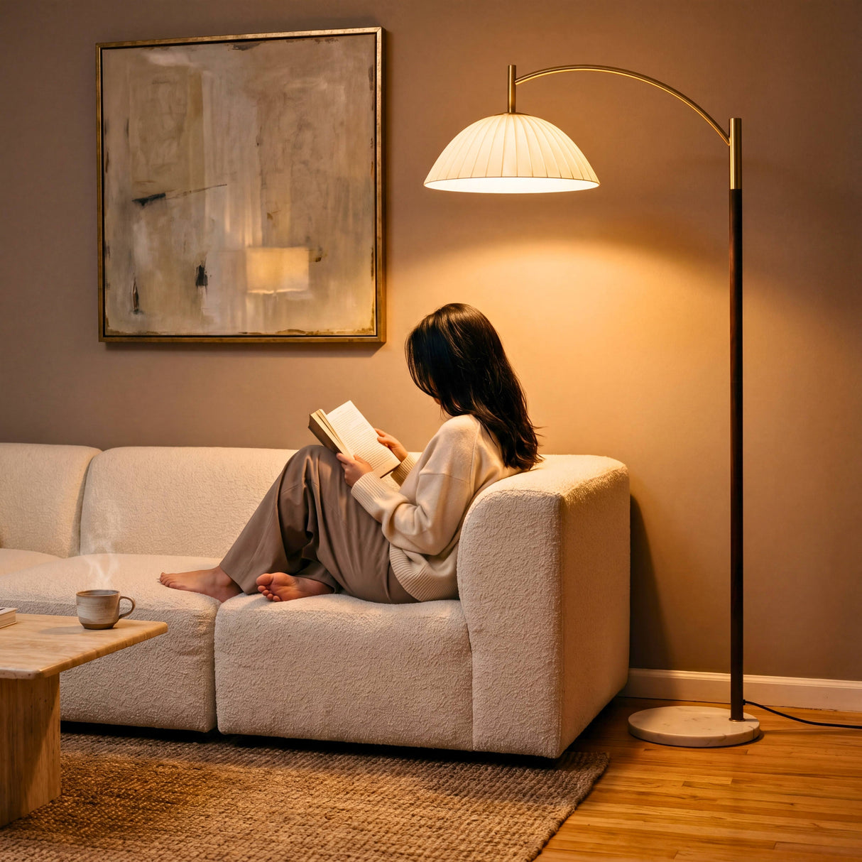 Luz de lectura indirecta en sofá mediante lámpara de pie arqueada de diseño minimalista.
