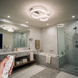 Aplicación de plafón circular en baño moderno con acabados en mármol y cristal.