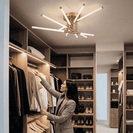 Plafón LED dorado en vestidor de alta gama con acabados en madera y luz cálida.