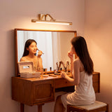 Mujer aplicándose maquillaje frente a espejo con la iluminación frontal del aplique Johana.