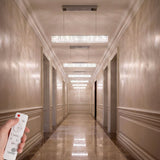 Sucesión de luminarias lineales en corredor largo para crear ritmo arquitectónico.