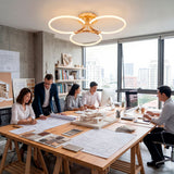 Plafón trío sobre mesa de reuniones en oficina técnica con planos y luz blanca.