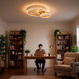 Plafón LED circular en zona de trabajo con ordenador y estanterías de libros.