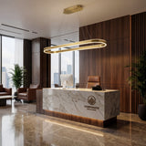 Lámpara de techo colgante lineal instalada sobre un mostrador de recepción de mármol elegante.