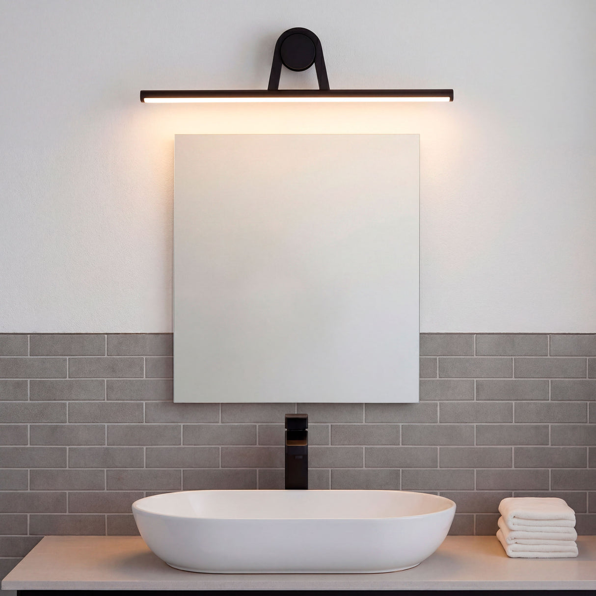 Distribución uniforme de luz blanca sobre espejo rectangular en un cuarto de baño de líneas limpias.