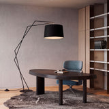 Lámpara de pie de diseño aportando luz directa cálida y eliminando sombras densas sobre la mesa de trabajo.