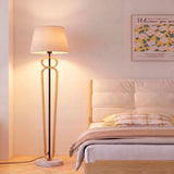Luminaria de lectura vertical junto a cama de arquitectura contemporánea aportando eficiencia lumínica.