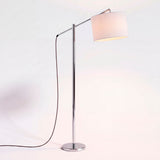 Luminaria esbelta con brazo extensible cromado y pantalla de tela blanca para una distribución lumínica limpia.