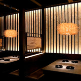 Serie de lámparas Harumi instaladas en comedor privado con paneles de madera.