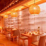 Línea de lámparas Nicole iluminando las mesas de un restaurante asiático contemporáneo.