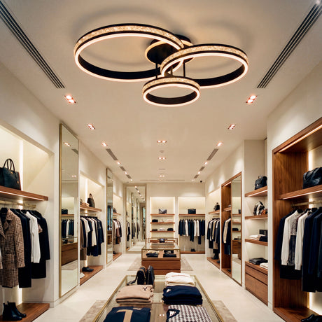Plafón LED de tres aros negros con efecto diamante en tienda de moda de alta gama.