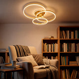 Plafón LED dorado sobre sillón de lectura en estancia con estanterías de libros.