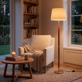 Lámpara decorativa al lado de un sillón orejero blanco en un rincón de descanso acogedor.
