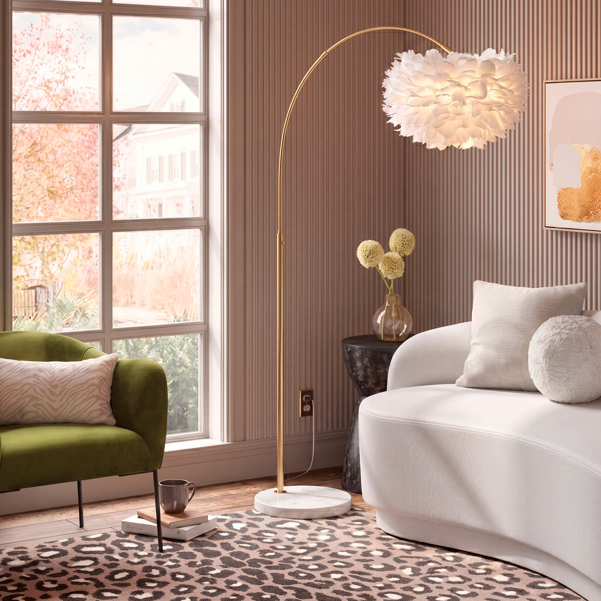 Modelo Carisma Gold extendiendo su brazo sobre un sofá blanco en un ambiente de diseño limpio.