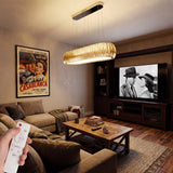 Luminaria colgante en sala de estar con luz cálida y diseño de cristal ámbar sobre mesa de centro.