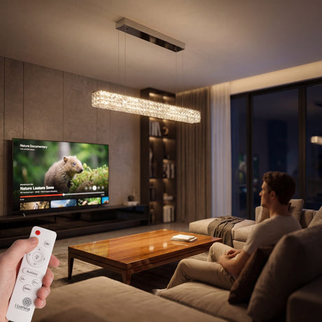 Luminaria lineal suspendida con cristales sobre zona de estar y control remoto inalámbrico.