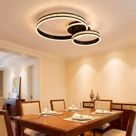 Plafón LED circular negro con difusor de efecto cristal sobre mesa de comedor elegante.