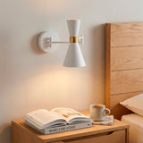 Punto de luz focal directo sobre mesa de noche que resalta acabados premium en interiorismo.