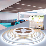 Iluminación lineal continua empotrada en falso techo de diseño minimalista para oficinas modernas.