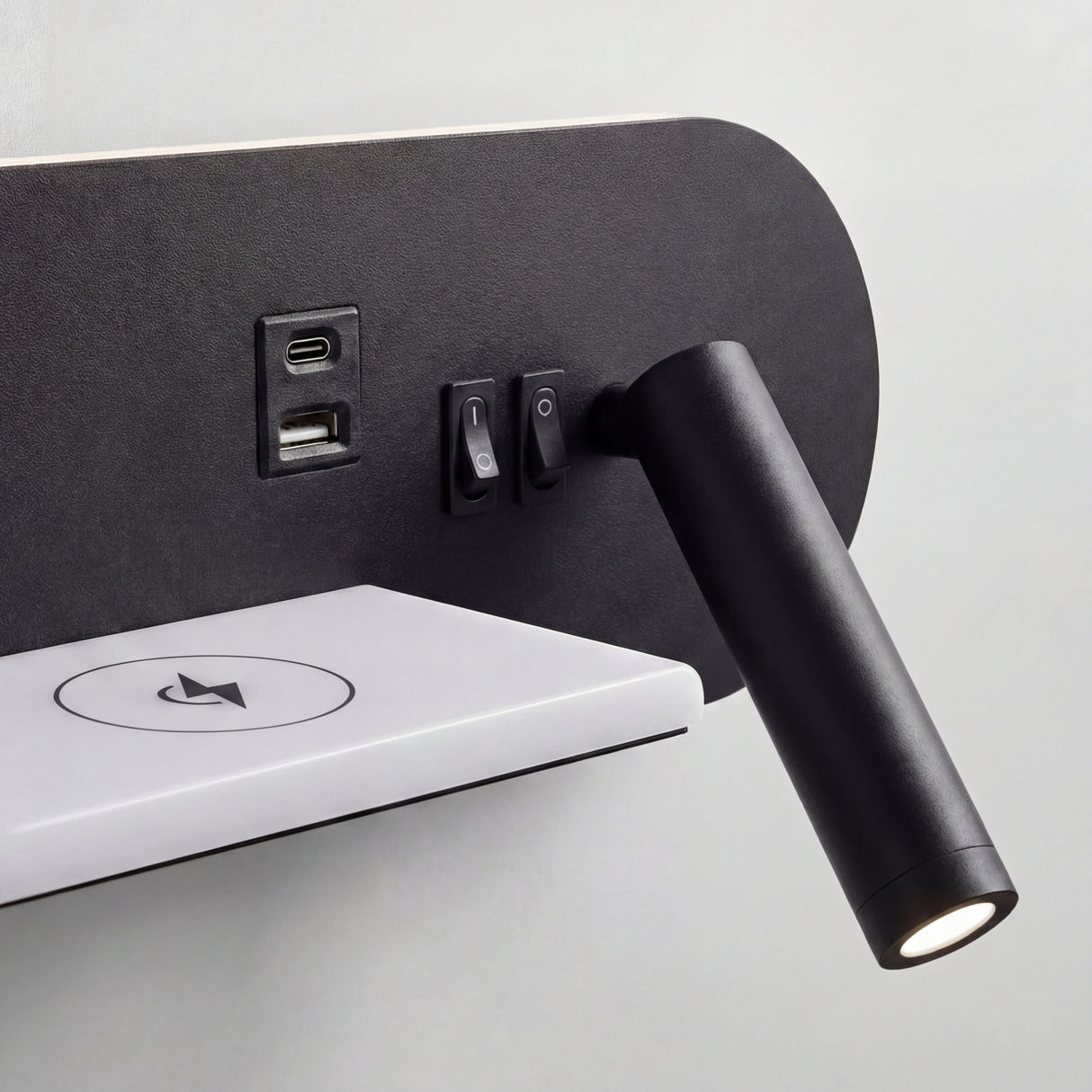 Detalle de puertos USB y base de carga Qi integrada en luminaria de diseño contemporáneo.